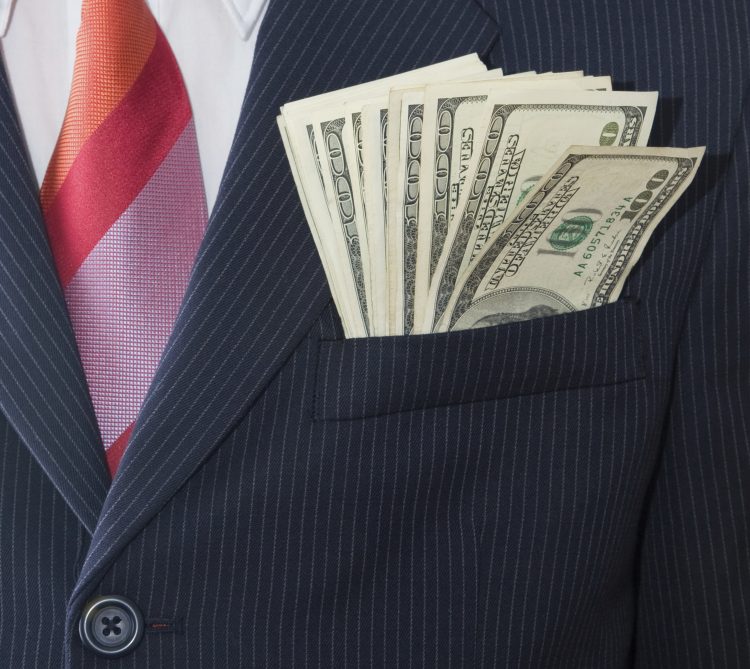 Business suit with 100 dollar bills coming out of pocket